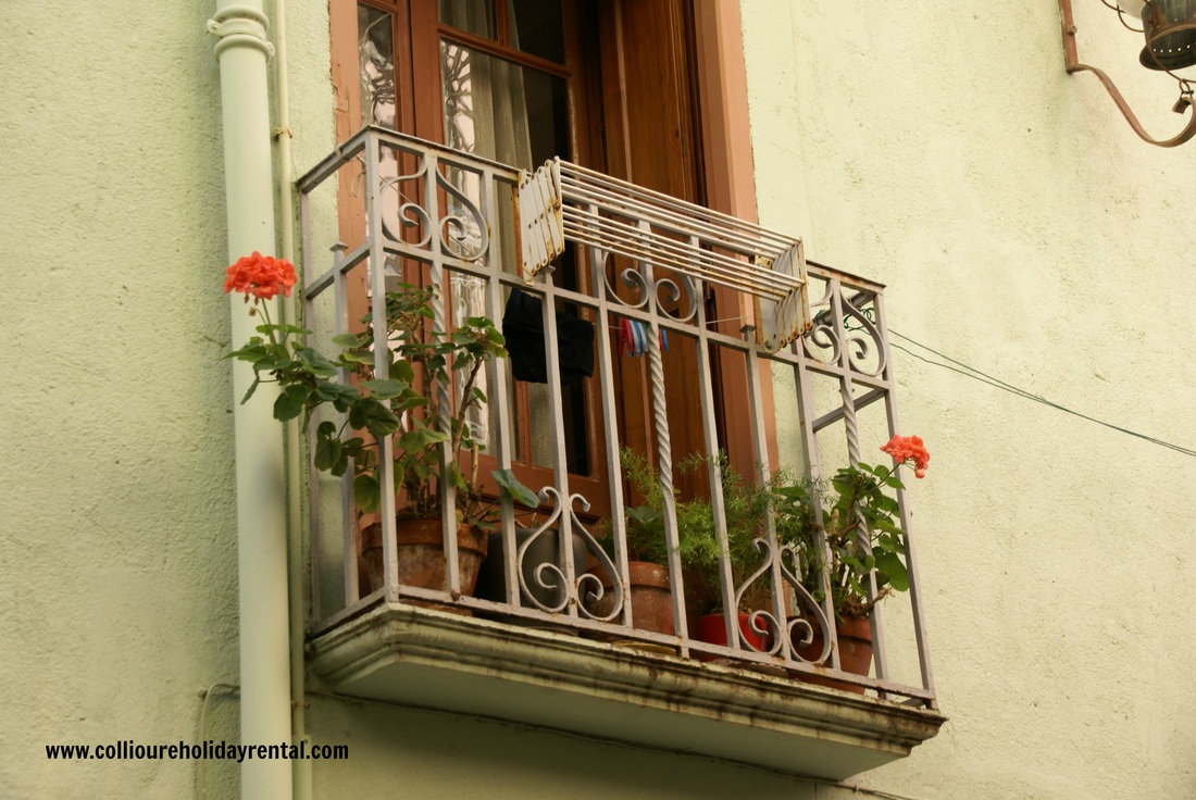 Wrought iron balcony with geraniums in Collioure